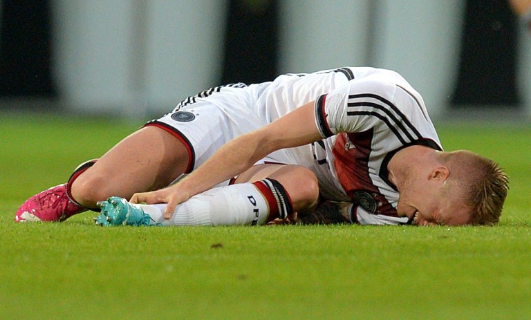 In this picture taken Friday June 6, 2014 German national soccer player  Marco Reus  lies on the pitch during the friendly soccer match between Germany and Armenia in Mainz Germany. Reus was helped off the pitch  after twisting his left ankle while challenging Artur Yedigaryan for the ball. Reus immediately dropped to the grass and appeared in considerable pain. Team doctor Hans-Wilhelm Mueller-Wohlfahrt shook his head as he assisted the Borussia Dortmund player off the pitch. Reus was taken to the hospital to determine the full extent of the injury. AP Photo/dpa,Thomas Eisenhuth)