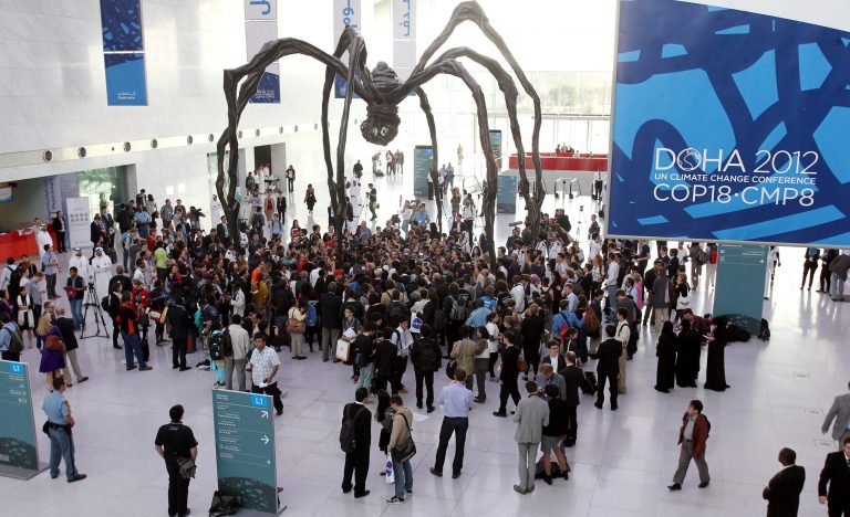   Local and international activists march inside a conference center under a giant statue of a spider to demand urgent action to address climate change at the U.N. climate talks in Doha, Qatar, Friday, Dec. 7, 2012. A dispute over money clouded U.N. climate talks Friday, as rich and poor countries sparred over funds meant to help the developing world cover the rising costs of mitigating global warming and adapting to it. (AP Photo/Osama Faisal)  