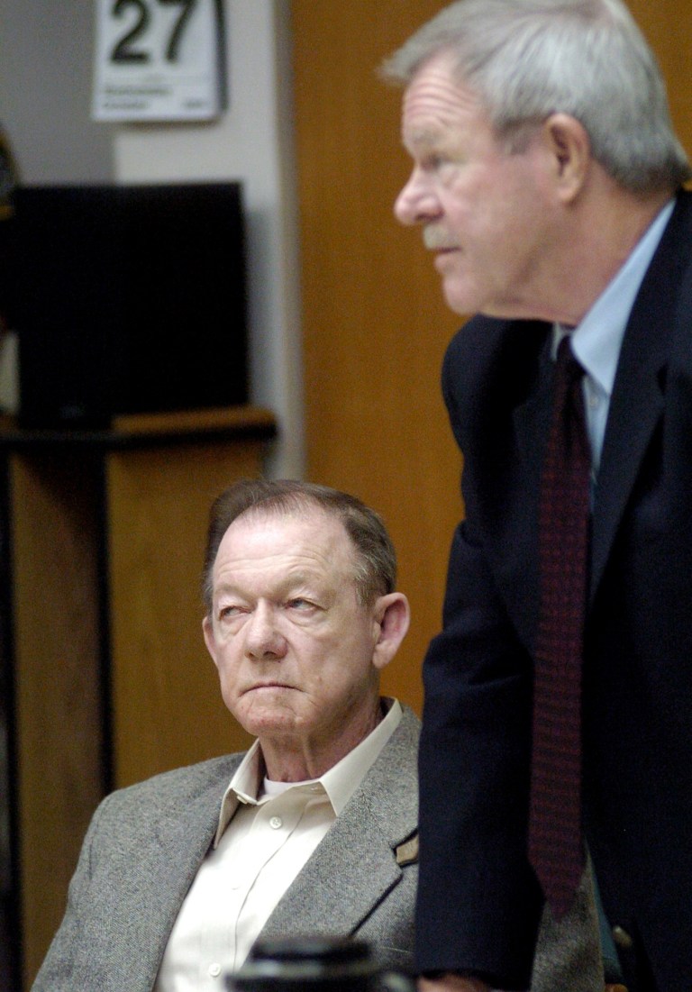   FILE - This Oct. 27, 2004 file photo shows Jack Lee Harelson, left, in Jackson County Circuit Court in Medford, Ore., with attorney Bob Abel. Authorities said Harelson, a former insurance agent and amateur archaeologist convicted of looting ancient Indian graves in the Nevada desert and later offering $10,000 in opals for a hit man to kill a former business partner, died Dec. 14, 2012 at the Oregon State Penitentiary in Salem, Ore. (AP Photo/Roy Musitelli, Pool, File)  