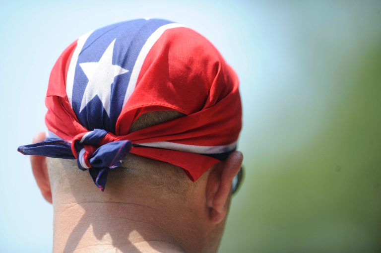 An individual wears a Confederate flag bandana on his head. (AP Photo/Mike Stewart)