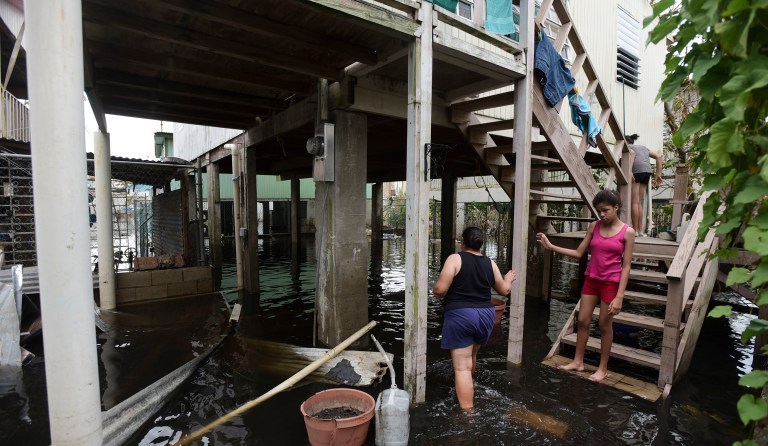 Juana Matos residents walk through a flooded area caused by the passage of Hurricane Maria, in Catano, Puerto Rico, Wednesday, Sept. 27, 2017. (AP Photo/Carlos Giusti)