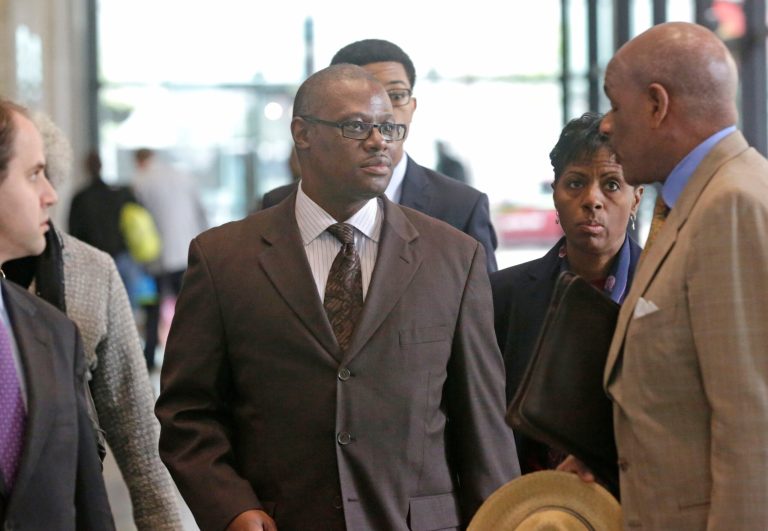 Illinois state Rep. Derrick Smith, center, listens to his attorney Victor Henderson, right, at the federal building Tuesday, June 10, 2014, in Chicago after a jury convicted him of bribery for taking $7,000 from a purported day care operator seeking a state grant. (AP Photo/M. Spencer Green)