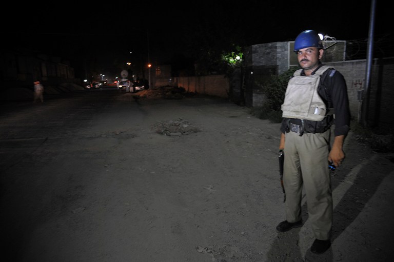 A Pakistani police officer stands guard near Peshawar airport which is cordon off, Wednesday, June 25, 2014 in Pakistan. Authorities in Pakistan were looking for a gunman who opened fire at a plane Tuesday evening just as it was landing in the volatile northwest, killing one person and wounding two others, officials said, casting fresh doubts about security at the country's airports. (AP Photo/Mohammad Sajjad)