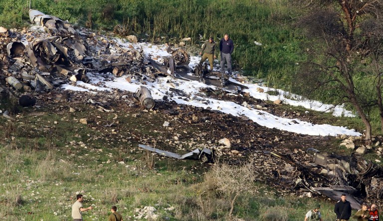 Israeli security stands around the wreckage of an F-16 that crashed in northern Israel, near the kibbutz of Harduf, on Saturday. The Israeli military shot down an Iranian drone it said infiltrated the country early Saturday before launching a 