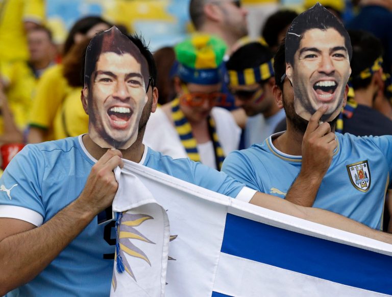 Uruguay fans wear masks of Uruguay's Luis Suarez before the World Cup round of 16 soccer match between Colombia and Uruguay at the Maracana Stadium in Rio de Janeiro, Brazil, Saturday, June 28, 2014. (AP Photo/Marcio Jose Sanchez)