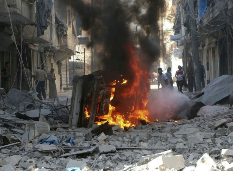 In this photo provided by the Syrian Civil Defense group known as the White Helmets, Syrians inspect damaged buildings after airstrikes by government helicopters on the rebel-held Aleppo neighborhood of Mashhad, Syria, Tuesday Sept. 27, 2016. (Syrian Civil Defense White Helmets via AP)