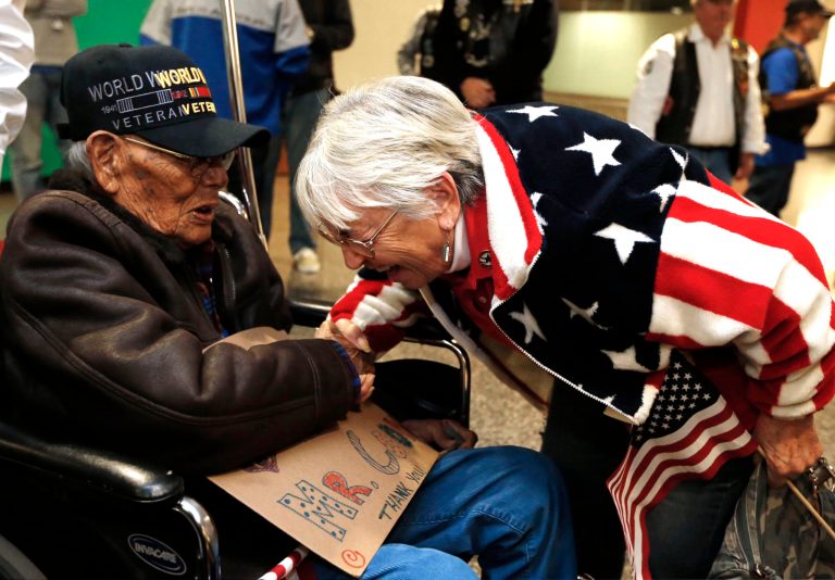 Sonja Gilmore, right, of the Blue Star Mothers Chapter 5 (Broken Arrow), chats with Phillip Coon, of Sapulpa, a 94-year-old World War II veteran who was a prisoner of war in Japan who survived the Bataan death march, moments after Coon's arrival from Japan, at the Tulsa International Airport, on Monday, Oct. 21, 2013. (AP Photo/Tulsa World, Cory Young)