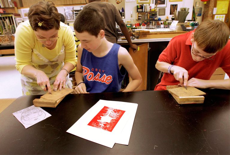   ADVANCE FOR USE SATURDAY, JUNE 16 AND THEREAFTER - In this May 11, 2012 photo, Springfield Southeast High School students are seen in the Principles of Art class in Springfield, Ill. Visual Arts Educator Lisa Long, left, helps students Dylan Walsh, center, and Ryeder Rettwghaus. Days after President Barack Obama called on the states to keep students in schools and raise the dropout age to 18, Illinois Gov. Pat Quinn proposed that Illinois should do so. Not everyone met the proposal with Quinn's enthusiasm, saying the state should consider it carefully before pushing up the age. (AP Photo/Seth Perlman)  