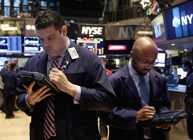 Robert McQuade, left, works with fellow traders on the floor of the New York Stock Exchange, Wednesday, Feb. 26, 2014. The stock market is little changed as investors pick over more earnings reports from retailers and other U.S. companies. (AP Photo/Richard Drew)