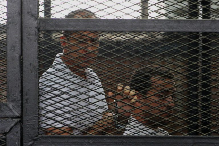 Australian correspondent of Al-Jazeera Peter Greste appears in a defendant cage along with other defendants during a trial on terrorism charges in Cairo, Egypt, Thursday, May 22, 2014. A defense lawyer for one of three Al-Jazeera journalists on trial in Egypt on terrorism charges has told the judge that the proceedings against his client 