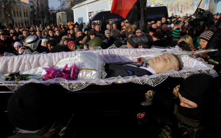 Protesters carry the coffin of Mikhail Zhiznevsky, 25, one of two protesters who died of gunshot wounds on Wednesday, during commemorate service in Kiev, Ukraine, Sunday Jan. 26, 2014. Ukraine's opposition called off a massive rally planned for Sunday because of the funeral for a protester killed in clashes with police last week, underscoring the rising tensions in the country's two-month political crisis. The opposition contends they were shot by police in an area where demonstrators had been throwing rocks and firebombs at riot police for several days. (AP Photo/Darko Vojinovic)