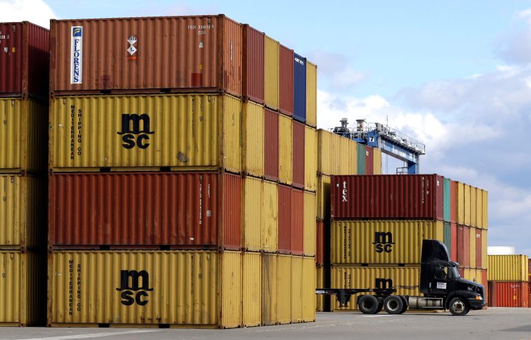 FILE- In this March 1, 2013 file photo, a truck drives past stacks of containers that were unloaded from a ship at the Port of Baltimore's Seagirt Marine Terminal in Baltimore.  The Commerce Department reports on wholesale prices for December on Wednesday, Jan. 15, 2014. (AP Photo/Patrick Semansky, File)