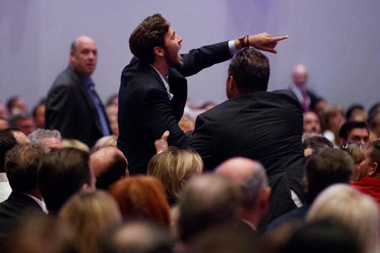 A protester is led away as Republican presidential candidate Donald Trump delivers an economic policy speech to the Detroit Economic Club. (AP Photo/Evan Vucci)