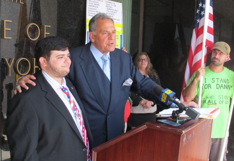Hofstra University student Daniel Martins, left, stands with his attorney, Thomas Liotti, at a press conference on Tuesday, July 1, 2014, in Mineola, N.Y. Martins is complaining that he was arrested while protesting against the policies of President Barack Obama on a Long Island Expressway overpass. He has pleaded not guilty to disorderly conduct and criminal nuisance charges.(AP Photo/Frank Eltman)