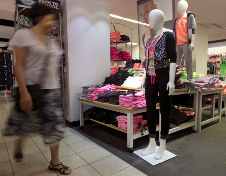 In this Tuesday, Aug. 19, 2014 photo, a woman passes an active wear display at a J.C. Penney store, in New York. The Commerce Department releases retail sales data for August on Friday, Sept. 12, 2014. (AP Photo/Richard Drew)