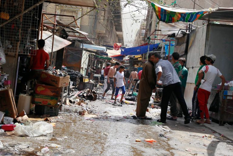 Civilians inspect the site of a bomb attack in Shorja Market in Baghdad, Iraq, Thursday, July 17, 2014. A bomb hidden in a wooden cart exploded near a Shiite mosque in one of Baghdad's largest markets, killing and wounding civilians. (AP Photo/Hadi Mizban)