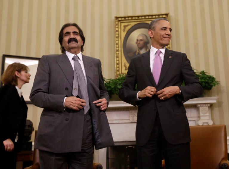 President Barack Obama, with Sheik Hamad bin Khalifa Al Thani of Qatar, stand up from their chairs following their meeting in the Oval Office of the White House in Washington, Tuesday, April 23, 2013. (AP Photo/Pablo Martinez Monsivais)