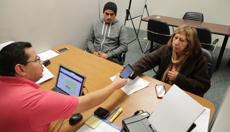 Community Council healthcare navigator helps a family sign up for the Affordable Care Act. Just over a third of the public knows the penalties for the uninsured were repealed as part of the tax bill signed by President Trump late last year. (AP Photo/LM Otero)