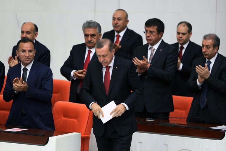 Ministers applaud Turkish Prime Minister Recep Tayyip Erdogan, front, at the parliament in Ankara, Turkey, Wednesday, April 23, 2014. Erdogan has issued a conciliatory message to Armenians on the eve of the anniversary of the massacre of Armenians almost a century ago, calling the events of World War I 