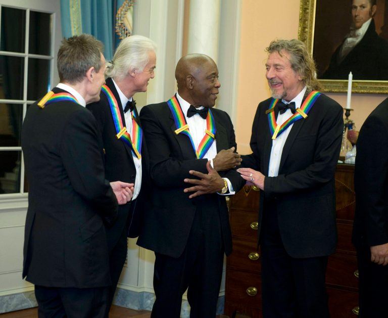   2012 Kennedy Center Honorees and members of Led Zeppelin John Paul Jones, left, Jimmy Page, second from left, and Robert Plant, right, talk with fellow 2012 Kennedy Center Honoree Buddy Guy at the end of the State Department Dinner for the Kennedy Center Honors gala Saturday, Dec. 1, 2012 at the State Department in Washington. (AP Photo/Kevin Wolf)  