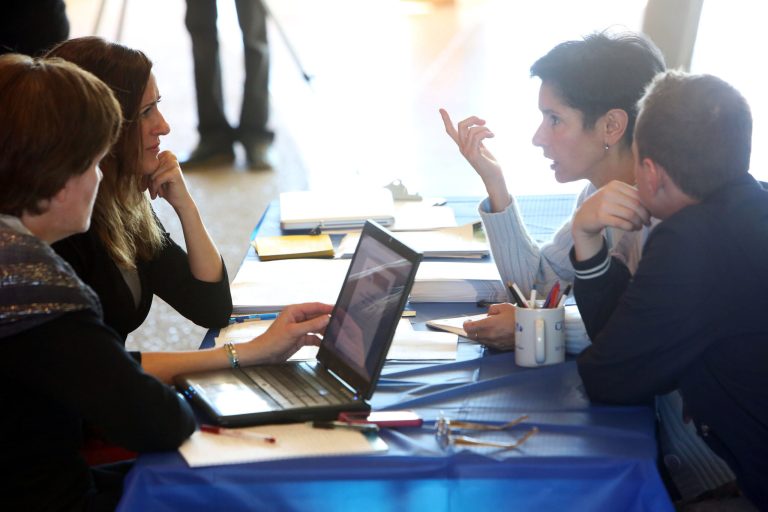 Jenifer Lloyd, left, and Azure Thompson help Margarita Gardner and her son Aleksandr Luchinovich navigate insurance options at the Sorenson Unity Center in Salt Lake on Oct. 1. (AP/Francisco Kjolseth)