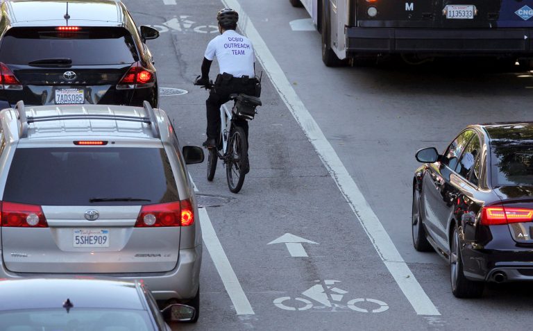 A cyclist maneuvers his way through downtown Los Angeles traffic on Tuesday, Sept. 16, 2014. California Gov. Jerry Brown announced Monday, Sept. 15, 2014 that he has signed legislation requiring California drivers to stay at least 3 feet away when passing bicyclists. The proposal is intended to better protect cyclists from aggressive drivers.   (AP Photo/Richard Vogel)