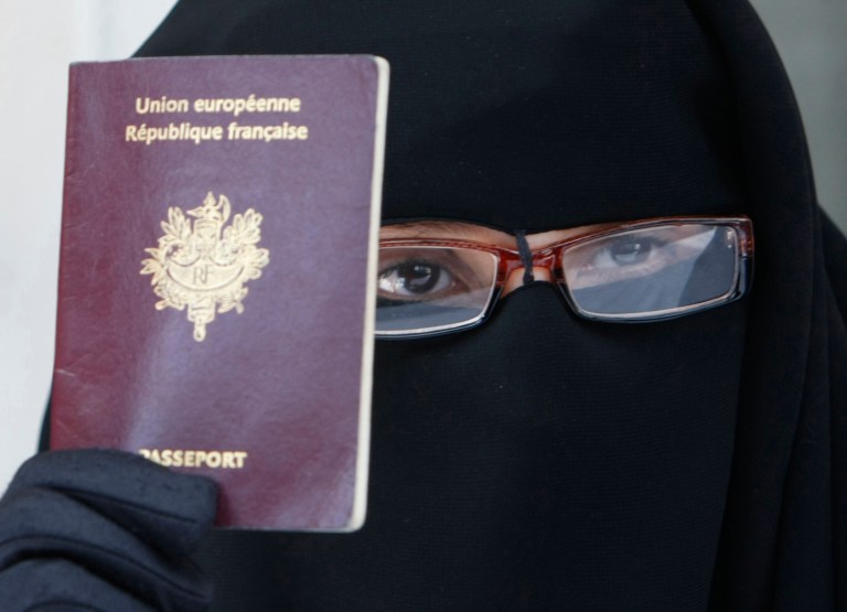 FILE - This May 18, 2010 file photo shows a woman, who gave her name as Najat, holding her passport during a press conference in Montreuil, east of Paris. The European Court of Human Rights on Tuesday, July 1, 2014, upheld France's law banning face-covering Muslim veils from the streets, in a case brought by another woman who claimed her freedom of religion was violated. (AP Photo/Remy de la Mauviniere, File)