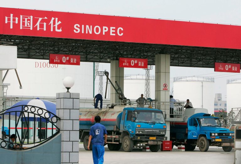 Workers fill oil into tank trucks at China Petroleum & Chemical Corp (Sinopec) Chengdu Company on August 24, 2005 in Chengdu of Sichuan Province, China. (Photo by China Photos/Getty Images)