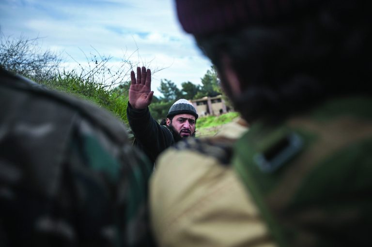 In this Saturday, Dec. 15, 2012 photo, a Free Syrian Army fighter leads his comrades during heavy clashes with government forces at a military academy besieged by the rebels north of Aleppo, Syria. Free Syrian Army fighters took control over the military academy after battling government forces for several hours. (AP Photo/Narciso Contreras)