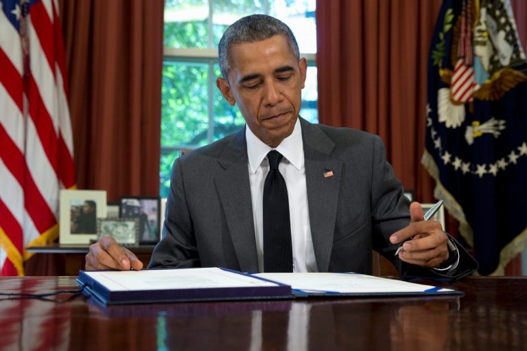 President Barack Obama signs the three-month highway funding bill in 2015. Regulations related to big bills signed into law are being rushed through to prevent Congress or the next president from changing them. (AP Photo/Carolyn Kaster)