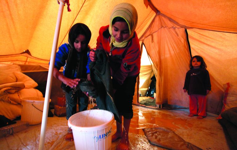 Syrian refugee girls remove water and mud from their tent after a flood at Zaatari Syrian refugee camp, near the Syrian border in Mafraq, Jordan, Tuesday, Jan. 8, 2013. Syrian refugees in a Jordanian camp attacked aid workers with sticks and stones on Tuesday, frustrated after cold, howling winds swept away their tents and torrential rains flooded muddy streets overnight. Police said seven aid workers were injured. (AP Photo/Mohammad Hannon)
