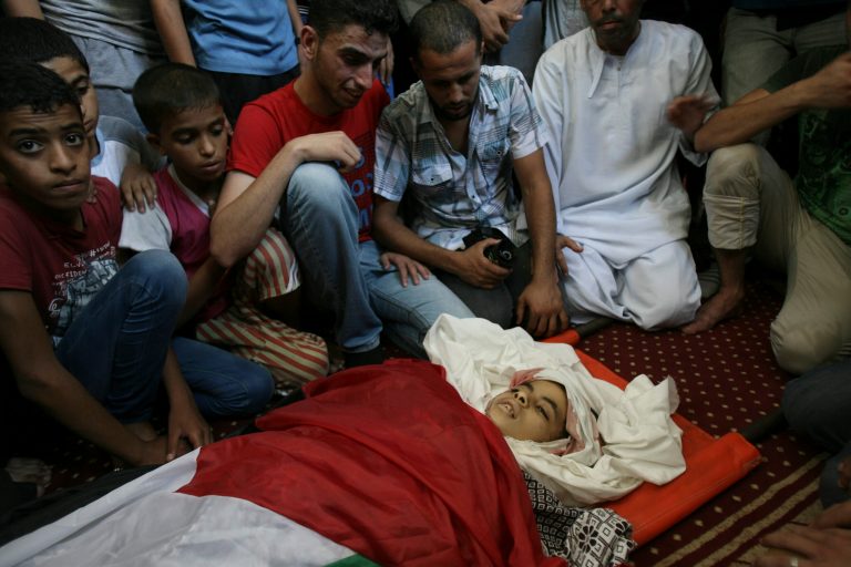 Palestinian relatives mourn over the body of Noor Alnajedy, 10,  who was killed during an Israeli air strike on a building near his family house, at the main mosque during his funeral in Rafah refugee camp, southern Gaza Strip, Friday July 11, 2014. Israel launched the Gaza offensive to stop incessant rocket fire that erupted after three Israeli teenagers were kidnapped and killed in the West Bank and a Palestinian teenager was abducted and burned to death in an apparent reprisal attack. The military says it has hit more than 1,100 targets already, mostly what it identified as rocket-launching sites, bombarding the territory on average every five minutes. (AP Photo/Eyad Baba)