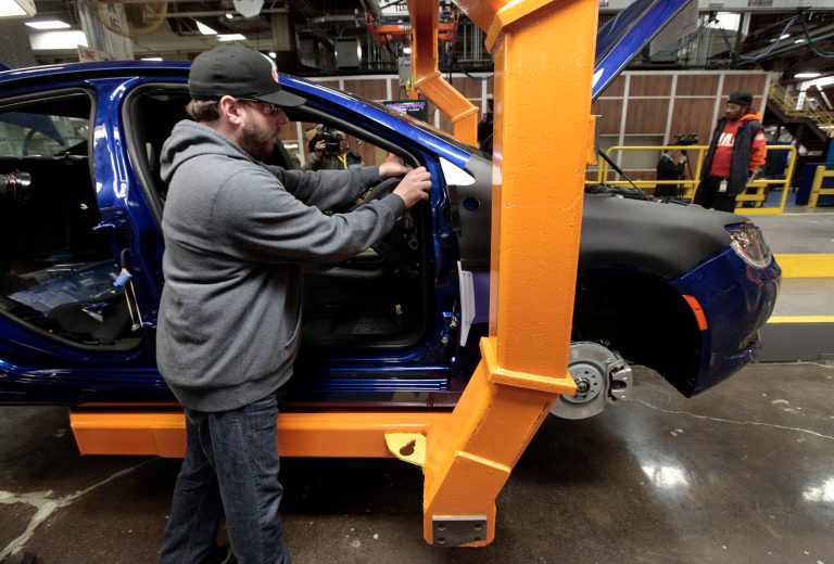 In this March 14, 2014 photo, an assembly line worker builds a 2015 Chrysler 200 automobile at the Sterling Heights Assembly Plant in Sterling Heights, Mich. The U.S. trade deficit fell in July to its lowest level since January, as exports of autos, telecom equipment, industrial machines and semiconductors rose, the Commerce Department reported Thursday, Sept. 4, 2014. (AP Photo/Paul Sancya)