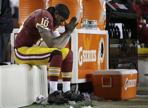 Washington Redskins quarterback Robert Griffin III sits on the bench after being injured during an NFL wild card playoff football game against the Seattle Seahawks in Landover, Md., Sunday, Jan. 6, 2013. The Seahawks defeated the Redskins 24-14. (AP Photo/Evan Vucci)