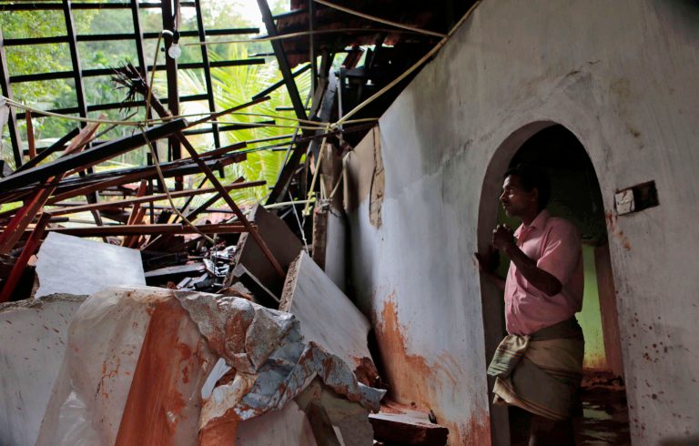 A Sri Lankan man stands in a house damaged by heavy rains in Mathugama, on the outskirts of Colombo, Sri Lanka, Tuesday, June 3, 2014. Many people have died in Sri Lanka from two days of floods and mudslides triggered by unusually heavy monsoon rains, officials said Tuesday. (AP Photo/Eranga Jayawardena)