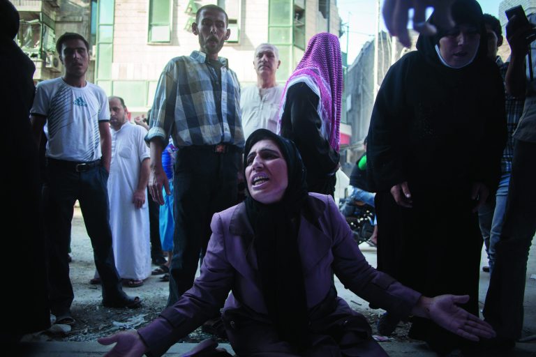 A woman cries near the body of her brother in front of Dar El Shifa hospital in Aleppo, Syria, Tuesday, Sept. 25, 2012. Over the past few months, rebels have increasingly targeted security sites and symbols of regime power in a bid to turn the tide in Syria's 18-month conflict, which activists say has left some 30,000 people dead.(AP Photo/Manu Brabo)
