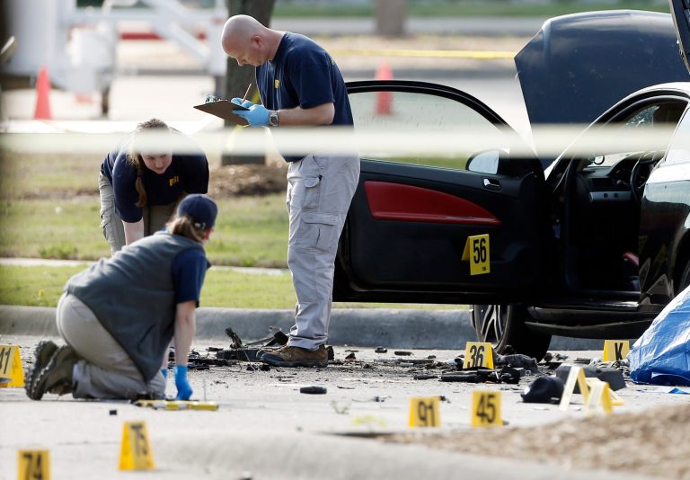 FBI crime scene investigators document the area around two deceased gunmen and their vehicle outside the Curtis Culwell Center in Garland, Texas, Monday, May 4, 2015. (AP Photo)Â 