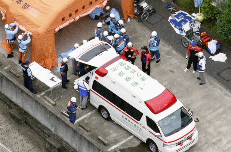 Ambulance crew and firefighters work outside a facility for the handicapped in Sagamihara, Japan, following a knife attack. (Kyodo News via AP)