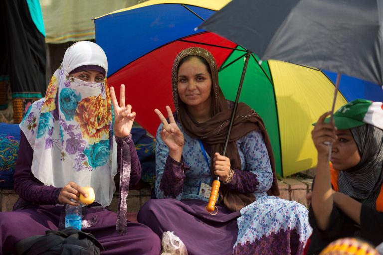 Supporters of anti-government cleric Tahir-ul-Qadri flash victory signs during a protest in front of the parliament building in Islamabad, Pakistan, Thursday, Aug. 21, 2014. Thousands of Khan's supporters are besieging parliament for a second day Thursday to pressure Prime Minister Nawaz Sharif to resign over alleged election fraud. (AP Photo/B.K. Bangash)