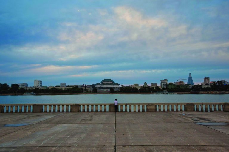 In this Thursday, Sept. 13, 2012 photo, a woman stands along the bank of the Taedong River at the end of the day in Pyongyang, North Korea. (AP Photo/David Guttenfelder)