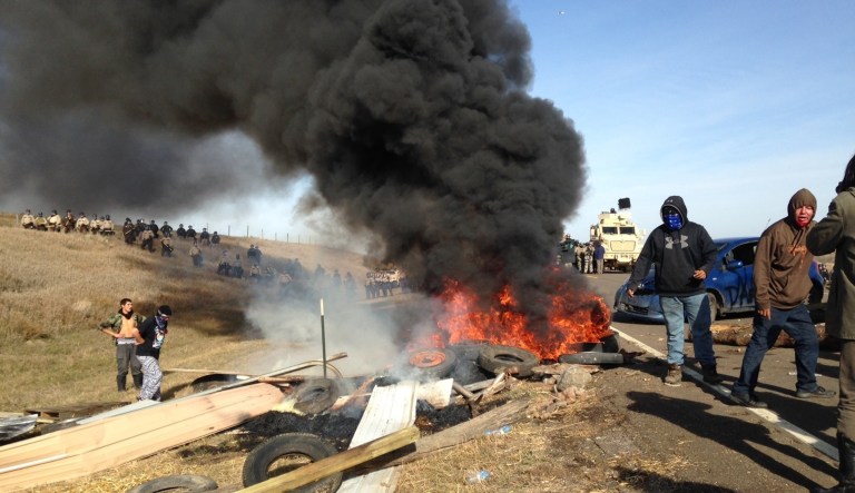 Dakota Access oil pipeline protesters burn debris as officers close in to force them from a camp on private land in the path of pipeline construction, Thursday, Oct. 27, 2016 near Cannon Ball, N.D. Soldiers and law enforcement officers dressed in riot gear began arresting protesters who had set up a camp on private land to block construction of the Dakota Access oil pipeline.