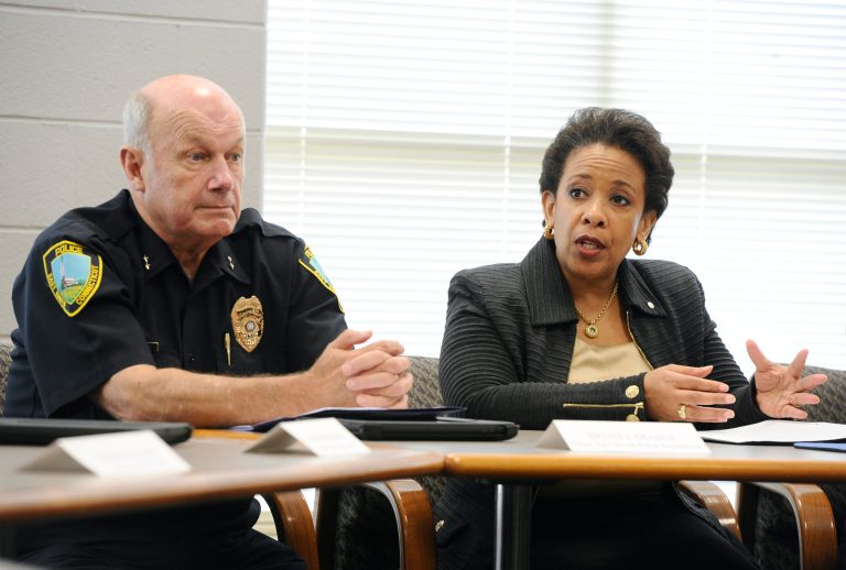 Attorney General Loretta Lynch, right, speaks as East Haven Police Chief Brent Larrabee, left, listens, during a community policing tour, Tuesday, July 21, 2015, in East Haven, Conn. (AP Photo/Jessica Hill)