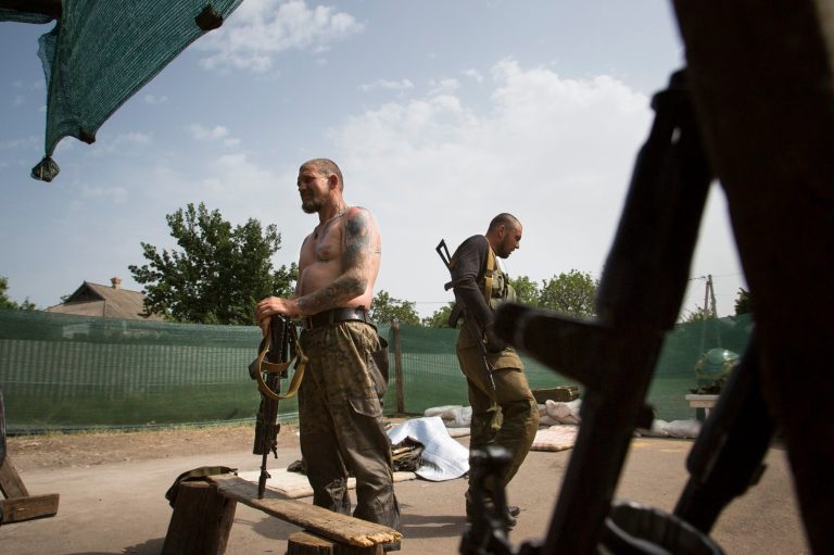 Pro-Russians rest at a checkpoint outside Slovyansk, eastern Ukraine, Monday, May 19, 2014.  Heavy mortar fire outside the eastern Ukrainian city of Slovyansk has damaged a large gas pipeline and set off a fire. Slovyansk has been the epicenter of fighting between Ukrainian troops and pro-Russian insurgents, who have seized government buildings across the east.  (AP Photo/Alexander Zemlianichenko)