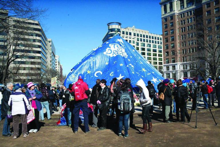 Occupy protesters erect a tarp over the statue of Gen. James McPherson in his namesake park Monday. U.S. Park Police had planned to start enforcing a camping ban.