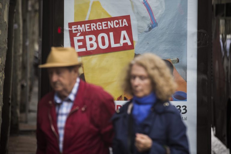 People walk past an advert calling for financial help to fight Ebola in Africa on Friday, Oct. 10, 2014 in Madrid downtown, Spain. A Spanish hospital official says the nursing assistant Teresa Romero, infected with Ebola, is 