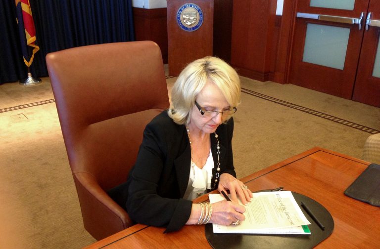 In this photo provided by by Ariz. Rep. Jeff Dial, Gov. Jan Brewer signs a proclamation calling the Legislature into special session, Tuesday, June 11, 2013, in Phoenix. Brewer acted after weeks of House delays in considering the state budget and her Medicaid expansion proposal. (AP Photo/Courtesy of Jeff Dial)