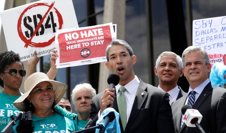 San Antonio Mayor Ron Nirenberg, center, stands with Austin Mayor Steve Adler, right, as he speaks to protesters at a rally in San Antonio on June 26 to oppose a new Texas 