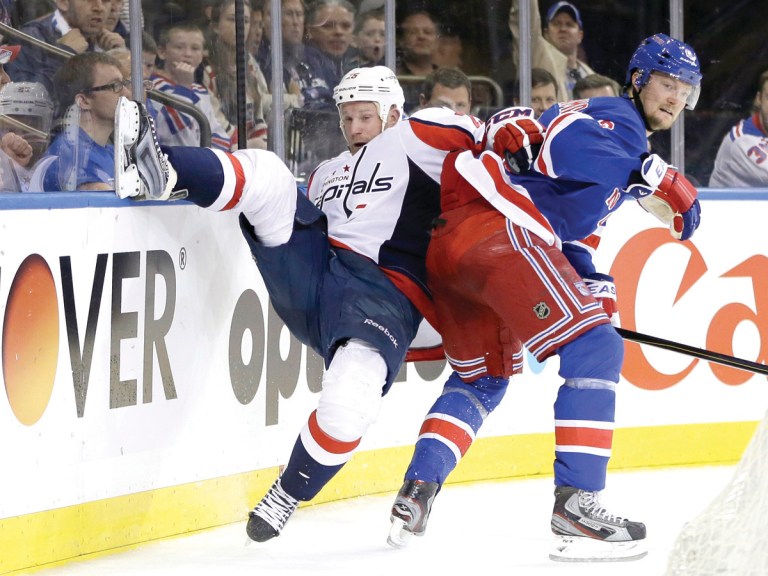 Kathy Willens/AP
The Rangers' Anton Stralman topples Capitals winger Jason Chimera with a check by the boards in New York's series-tying win over Washington on Sunday.