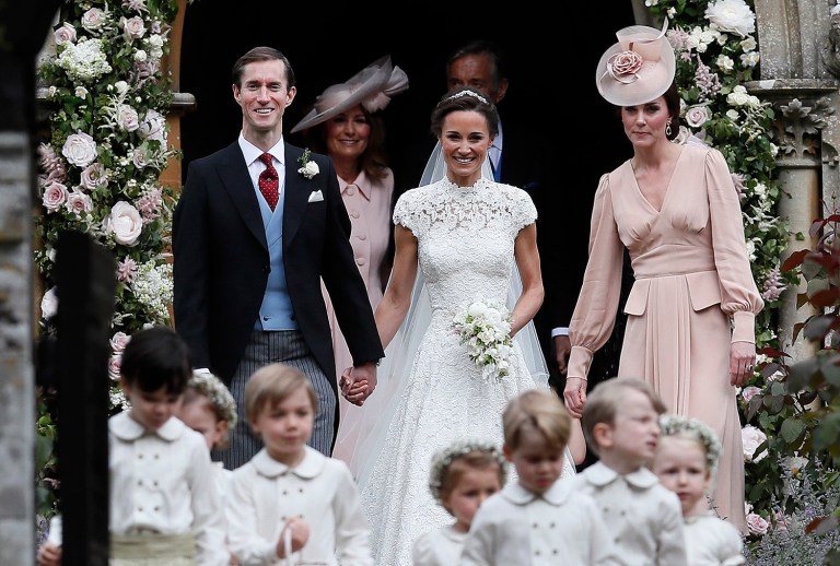 Pippa Middleton and James Matthews smile as they are joined by Kate, Duchess of Cambridge, right, after their wedding at St Mark's Church in Englefield, England Saturday, May 20, 2017. Middleton, the sister of Kate, Duchess of Cambridge married hedge fund manager James Matthews in a ceremony Saturday where her niece and nephew Prince George and Princess Charlotte was in the wedding party, along with sister Kate and princes Harry and William. (AP Photo/Kirsty Wigglesworth, Pool)