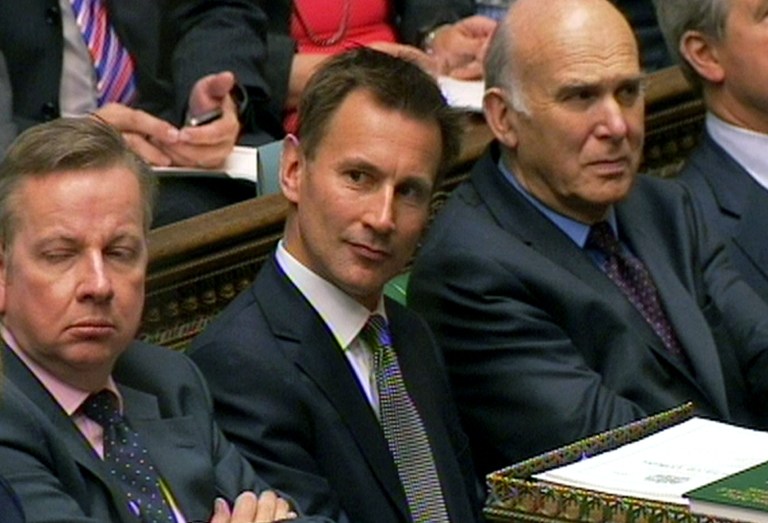   Britain's Culture Secretary Jeremy Hunt, center, looks on as Prime Minister David Cameron speeks during Prime Minister's Questions in the House of Commons, London Wednesday June 13, 2012. Britainâs coalition government is split on whether to back a Conservative minister over the way he dealt with Rupert Murdochâs News Corp. The British media, including Press Association, say Deputy Prime Minister and Liberal Democrat leader Nick Clegg has asked his lawmakers to abstain on a vote Wednesday afternoon on whether Culture Secretary Jeremy Hunt should be investigated over how he dealt with News Corp. as it was trying to take full control of a satellite broadcaster in which News Corp. already holds a 39 percent stake. (AP Photo/PA Wire) UNITED KINGDOM OUT  